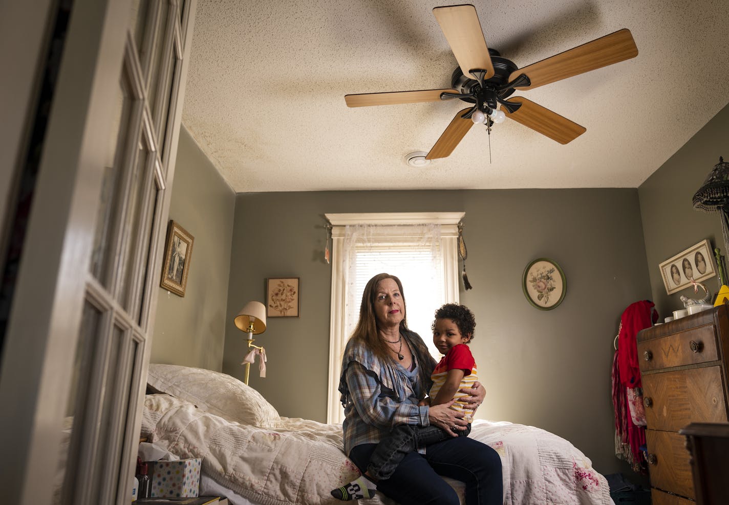 Kris Gronquist, with 3-year-old grandson Tia'aj White, is trying to get her vintage ceiling fans repaired.