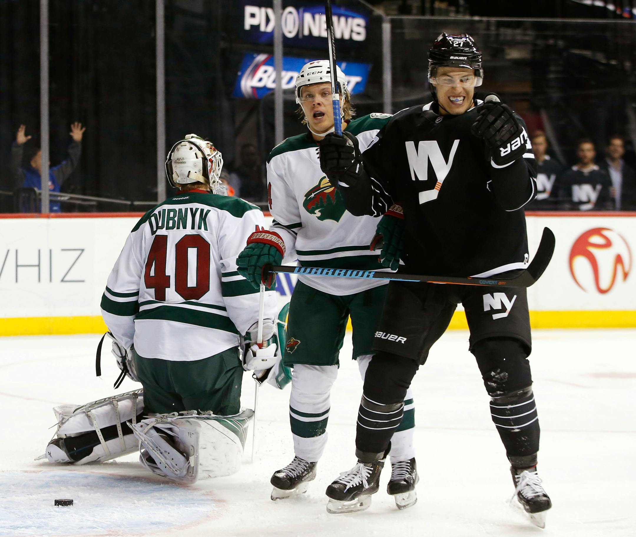 New York Islanders center Anders Lee (27) celebrates after scoring a goal on Minnesota Wild goalie Devan Dubnyk (40) during the second period of an NHL hockey game in New York, Tuesday, Feb. 2, 2016. Wild's Mikael Granlund is at center. (AP Photo/Kathy Willens)