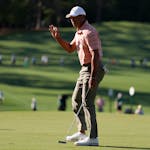 Tiger Woods waves after making a putt on the seventh hole during the first round at the Masters on Thursday.
