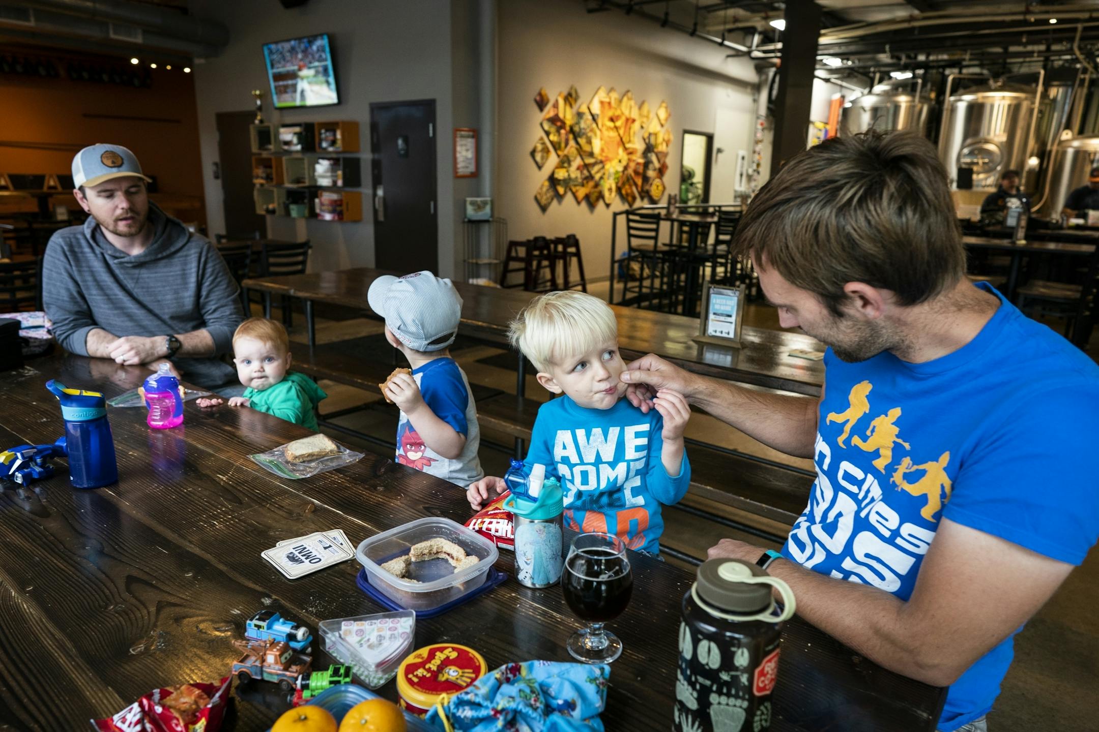 Keith Nagel and his son Sawyer, 3, eat lunch at Omni Brewing during a Twin Cities Dads playgroup.