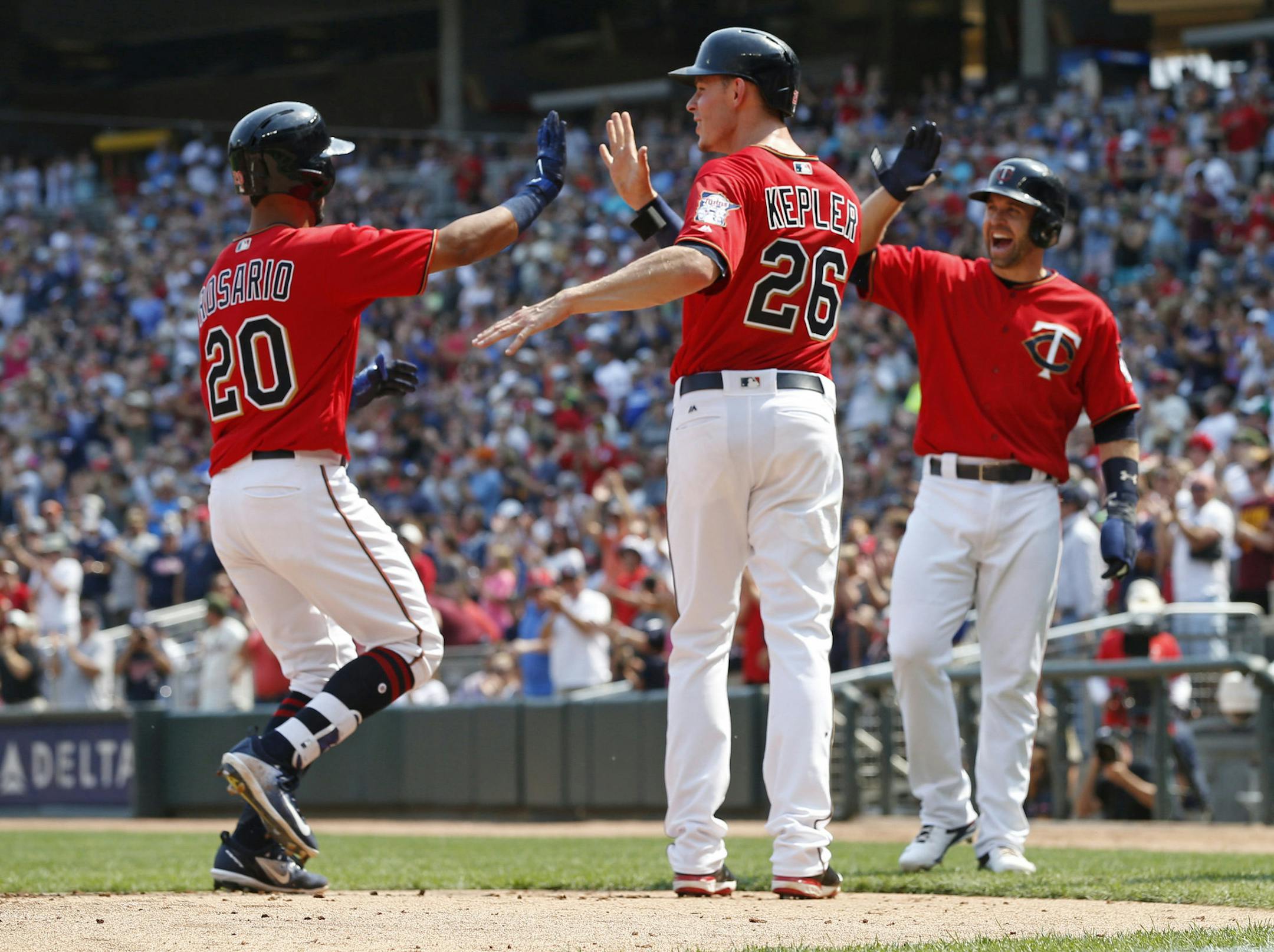 Twins left fielder Eddie Rosario was congratulated by Max Kepler and Brian Dozier, right, following his grand slam off Arizona&#x2019;s Braden Shipley on Sunday at Target Field.