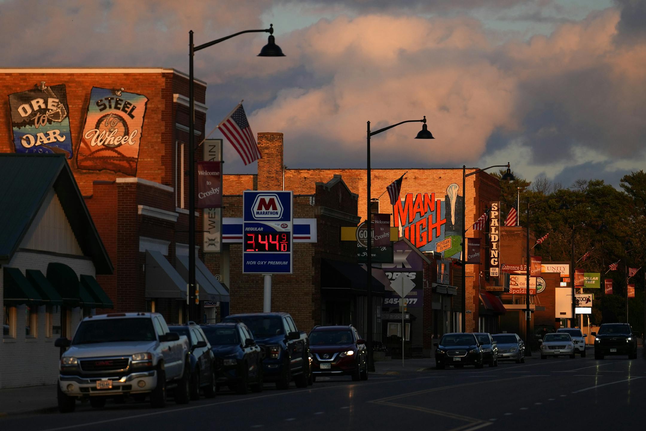 The setting sun illuminates the downtown main street that has both shops and restaurants catering to the mountain bikers who flock to the area for the Cuyuna Country State Recreation Area, Wednesday, Oct. 4, 2023 in Crosby, Minn. The Man High mural is a reference to the 1957 launch of Manhigh II by Major David G. Simons in August 1957, launched from Portsmouth Mine in Crosby. ] ANTHONY SOUFFLE • anthony.souffle@startribune.com