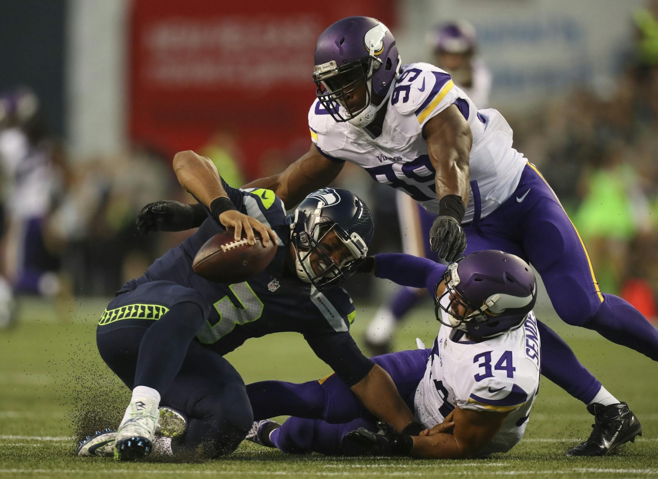 Vikings strong safety Andrew Sendejo (34) sacked Seattle Seahawks quarterback Russell Wilson for an 18 yard loss as teammate Danielle Hunter (99) backed him up in the second quarter Thursday night.
