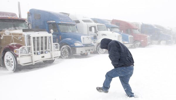 Wes Bevans, a truck driver from Northern California, walks to his truck at the Flying J Travel Plaza in Grand Forks, N.D., Monday. Dozens of semi truc