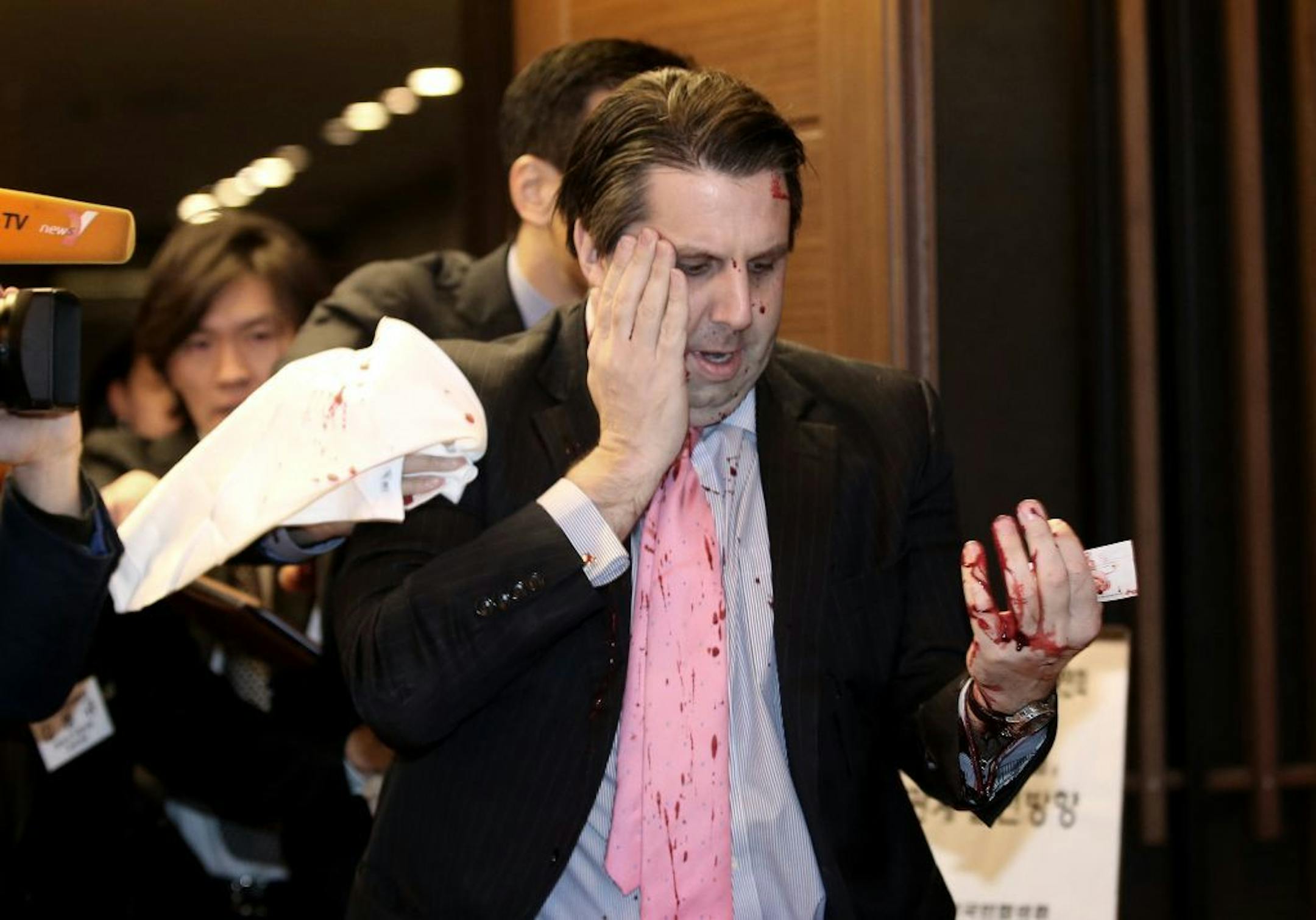 U.S. Ambassador to South Korea Mark Lippert leaves a lecture hall for a hospital in Seoul, South Korea, Thursday, March 5, 2015 after being attacked by a man. Lippert was attacked by a man wielding a razor and screaming that the rival Koreas should be unified, South Korean police and media said Thursday. (AP Photo/Yonhap, Kim Ju-Sung) KOREA OUT