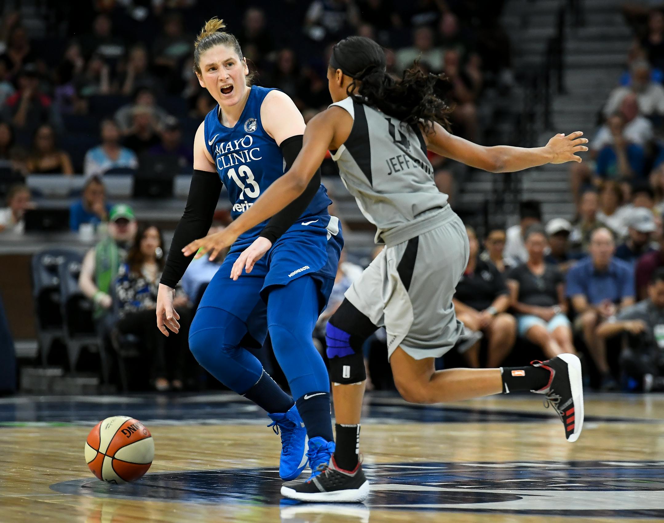 Lynx guard Lindsay Whalen directs teammates while moving the ball down the court under defense by Las Vegas Aces guard Moriah Jefferson