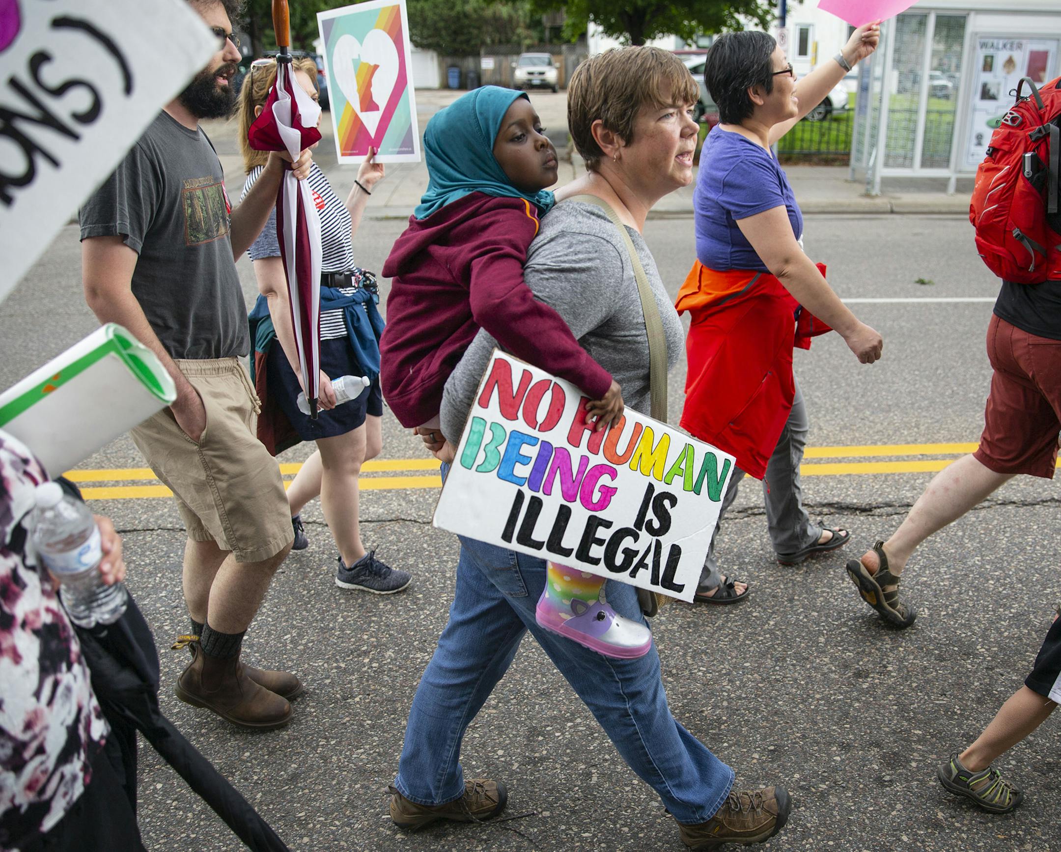 Approximately 1,000 people marched through the streets of Minneapolis on Sunday to protest the treatment of migrants on the U.S. border. Above, Hikmah Warsame rode on the back of her mother's friend, Anna Kam, during the march.