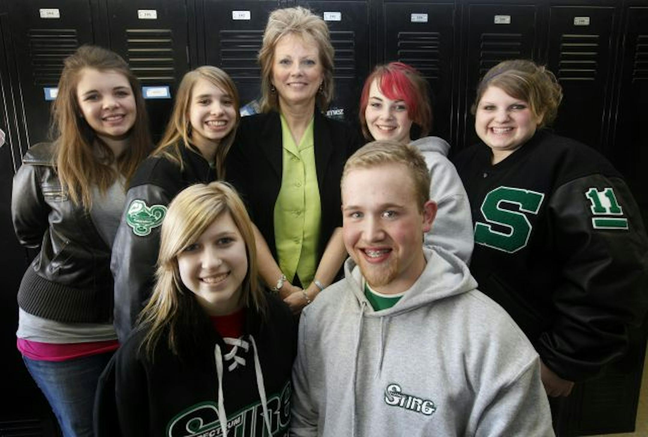 Students at Spectrum High School collected $300 to pay bills for a family hospitalized after a car accident. Clockwise from top left, Laura Ness, Melanie Newberger, Principal Vanessta Spark, Kaitlyn Aberle, Mandy Jahner, Tim Serbus and Hayley Wrede took the check to Elk River Municipal Utilities.