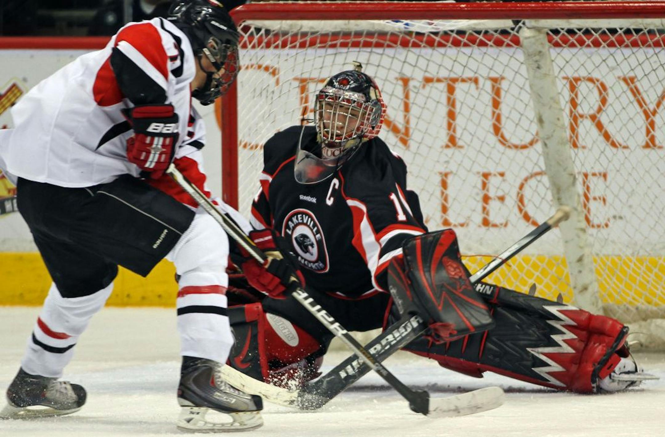Boys Hockey Tournament Class 2A Quarterfinal, Eden Prairie vs Lakeville North. (left to right) Eden Prairie's Kyle Rau skated and scored on Lakeville North goalie Charlie Lindgren.