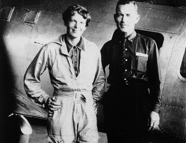 FILE - In this May 1937 file photo, American aviaor Amelia Earhart and her navigator, Fred Noonan, pose in front of their twin-engine Lockheed Electra