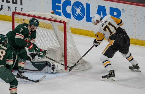 Pittsburgh Penguins center Evgeni Malkin (71) taps the puck past Minnesota Wild goaltender Cam Talbot (33) to win the game 4-3 in overtime.