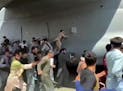 Thousands of Afghans rushed onto the tarmac at the airport in Kabul on Monday, some so desperate to escape the Taliban capture of their country that t