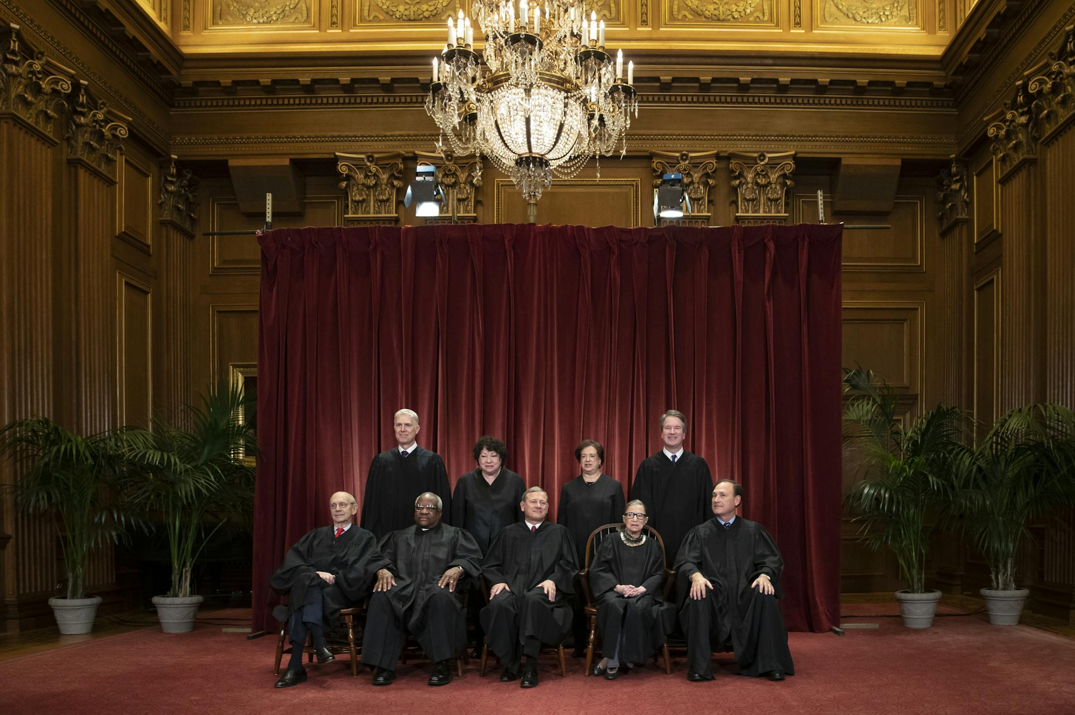 FILE- In this Nov. 30, 2018, file photo the justices of the U.S. Supreme Court gather for a formal group portrait to include a new Associate Justice, top row, far right, at the Supreme Court Building in Washington. Seated from left: Associate Justice Stephen Breyer, Associate Justice Clarence Thomas, Chief Justice of the United States John G. Roberts, Associate Justice Ruth Bader Ginsburg and Associate Justice Samuel Alito Jr. Standing behind from left: Associate Justice Neil Gorsuch, Associate