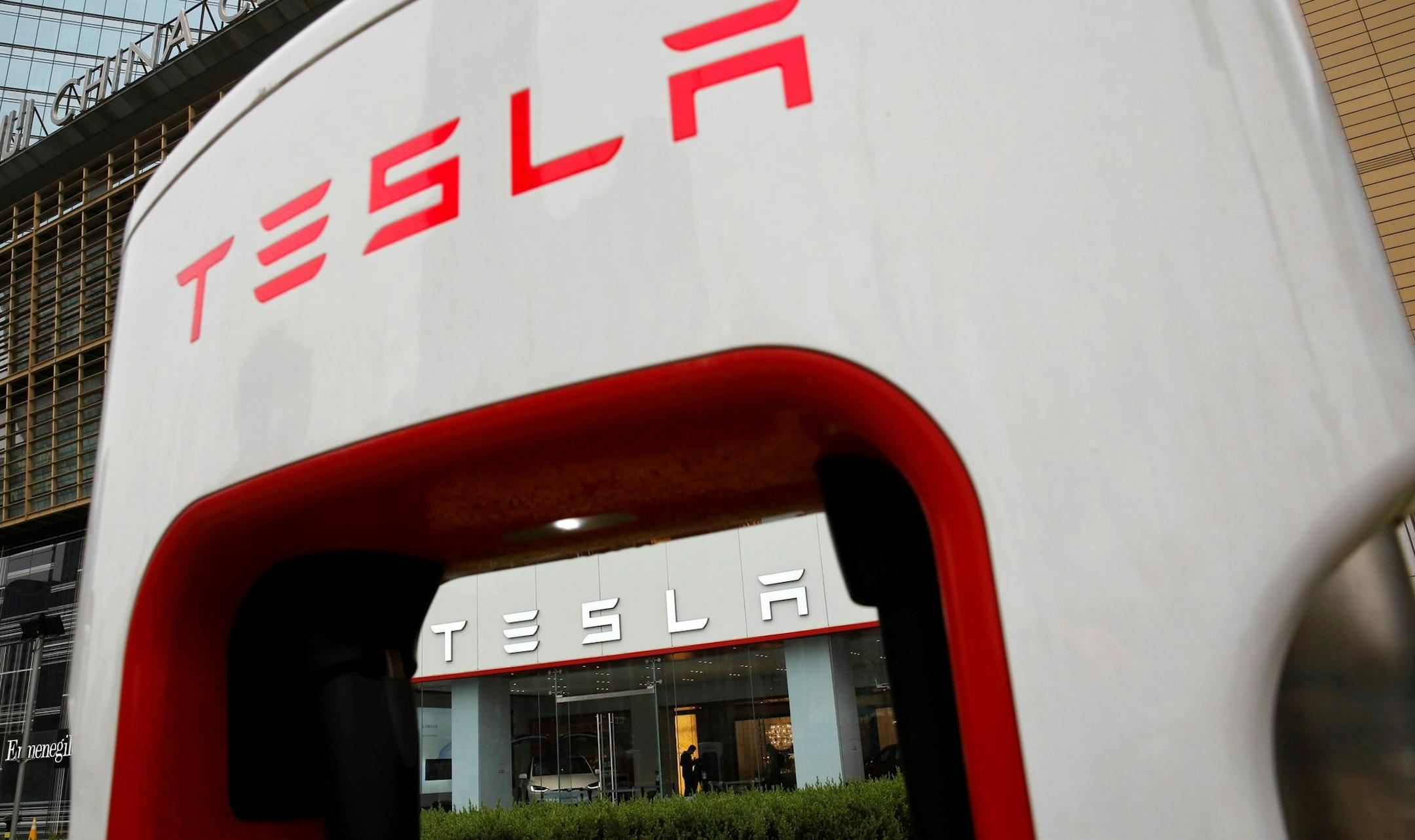 A sales person stands inside a Tesla electric vehicle showroom in Beijing, Thursday, April 5, 2018. The United States and China, the world's two largest economies, have roiled financial markets and fueled fears of a protracted trade war by threatening tariffs this week on each other's goods. The United States on Tuesday said it would impose 25 percent duties on $50 billion of imports from China, and China quickly retaliated by listing $50 billion of products that it could hit with its own 25 per