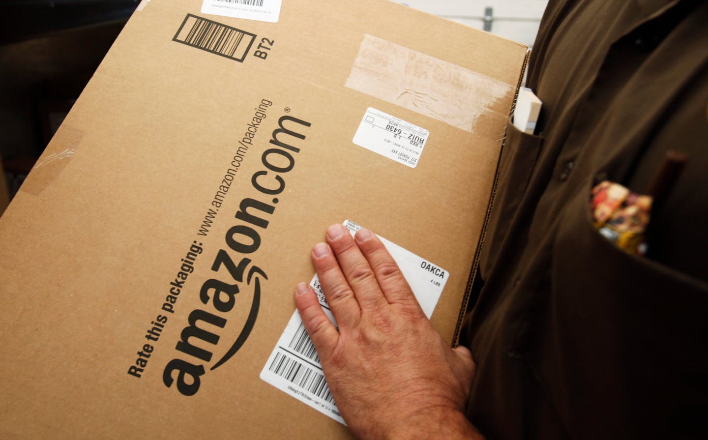 In this file photo, an Amazon.com package is prepared for shipment by a United Parcel Service driver in Palo Alto, Calif.