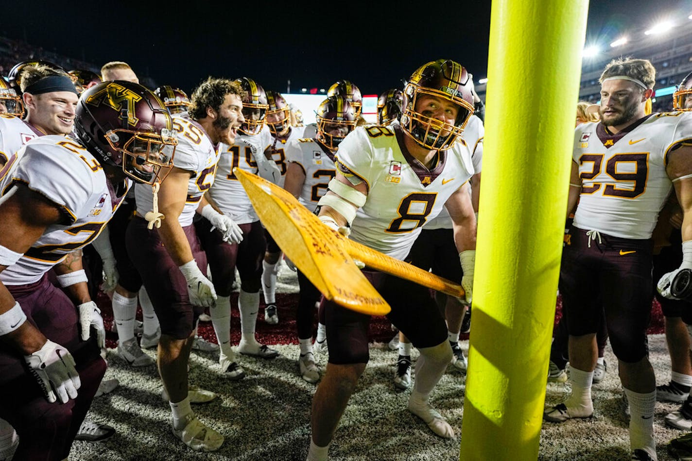 Minnesota quarterback Athan Kaliakmanis (8) celebrates with the Paul Bunyan's Axe trophy Saturday.