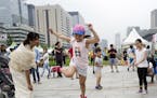 Children play a traditional Filipino game in a cultural experience zone on Gwanghwamun Square in Seoul. Illustrates TRAVEL-SEOUL (category t), by Tom 