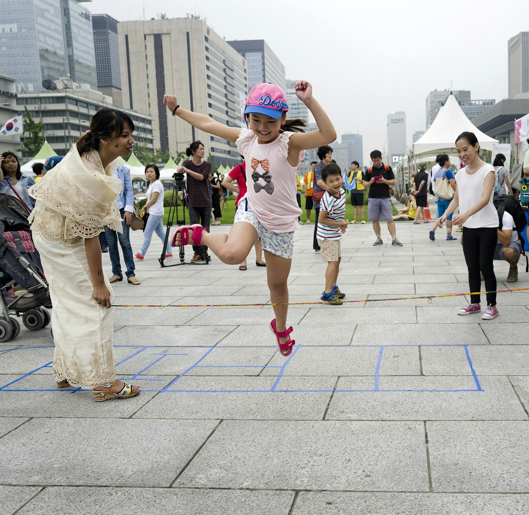 Children play a traditional Filipino game in a cultural experience zone on Gwanghwamun Square in Seoul. Illustrates TRAVEL-SEOUL (category t), by Tom Shroder, special to The Washington Post. Moved Tuesday, Sept. 15, 2015. (MUST CREDIT: Photo for The Washington Post by Shin Woong-jae.)