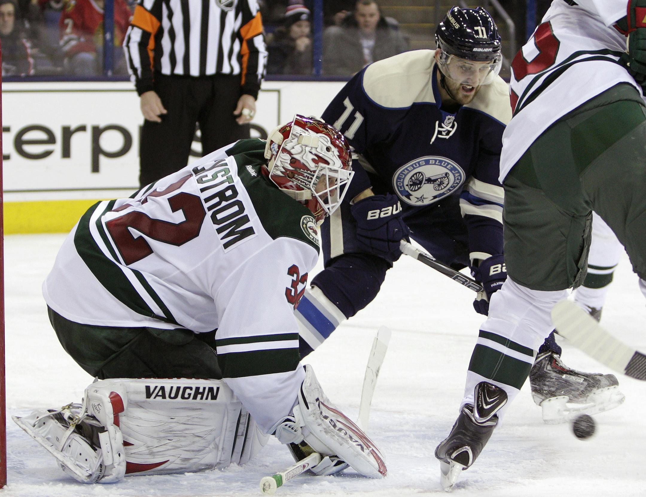 Minnesota Wild's Niklas Backstrom, left, of Finland, makes a save as Columbus Blue Jackets' Nick Foligno waits for the rebound during the second period of an NHL hockey game on Friday, Dec. 6, 2013, in Columbus, Ohio. (AP Photo/Jay LaPrete)