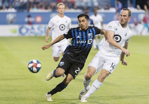 Montreal Impact's Mathieu Choiniere, left, tries to fend off Minnesota United's Brent Kallman during the second half of an MLS soccer match Saturday, 