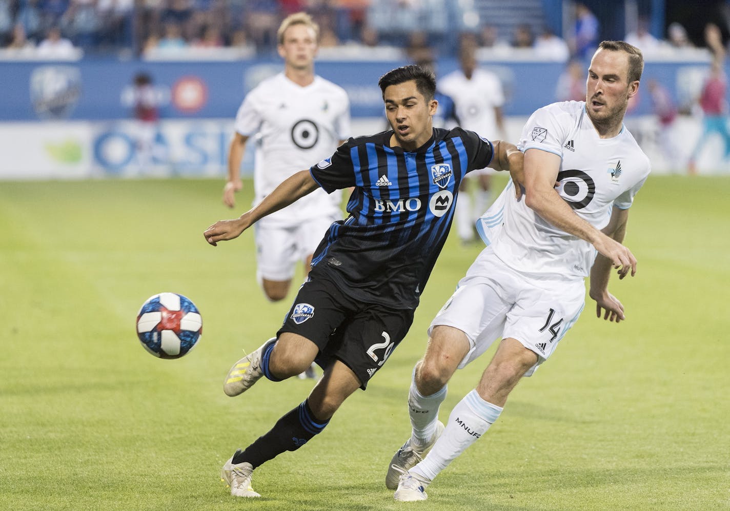 Montreal Impact's Mathieu Choiniere, left, tries to fend off Minnesota United's Brent Kallman during the second half of an MLS soccer match Saturday, July 6, 2019, in Montreal. (Graham Hughes/The Canadian Press via AP)