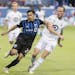 Montreal Impact's Mathieu Choiniere, left, tries to fend off Minnesota United's Brent Kallman during the second half of an MLS soccer match Saturday, 
