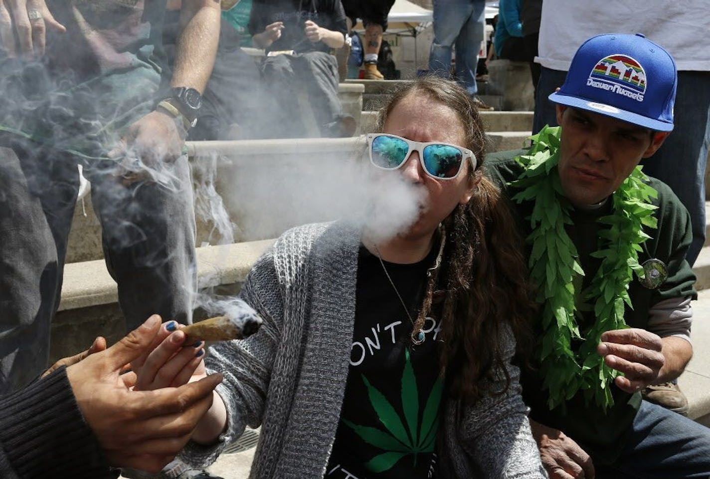 Partygoers listen to music and smoke marijuana on one of several days of the annual 4/20 marijuana festival, in Denver's downtown Civic Center Park, Saturday, April 18, 2015. The annual event is the second 4/20 marijuana celebration since retail marijuana stores began selling in January 2014.