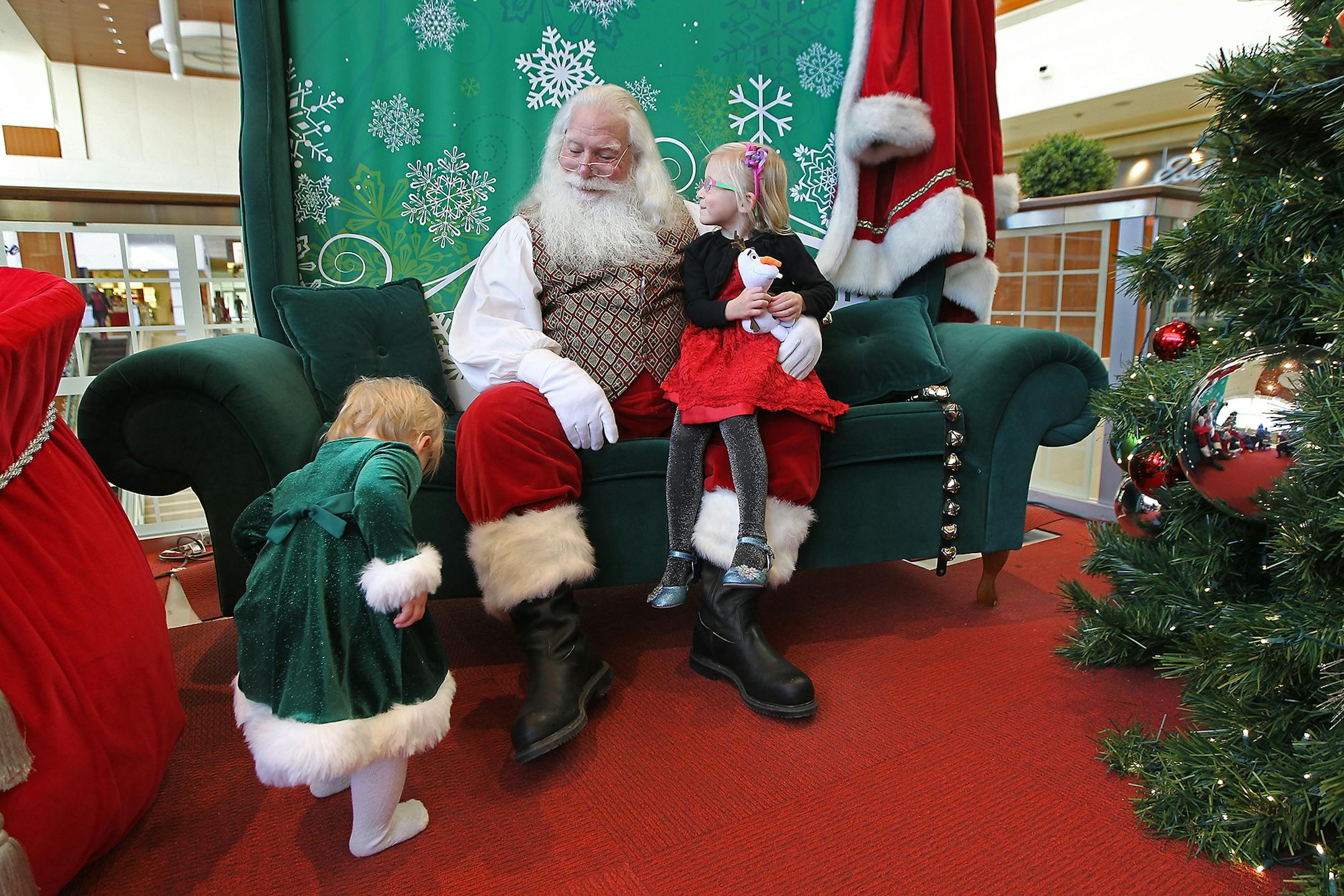 Lila Alme, 4, of Farmington, MN, was all smiles as she sat with "Santa" and tried to encourage her sister Olivia, 15 months, to join them at Southdale Mall in Edina on Dec. 4.