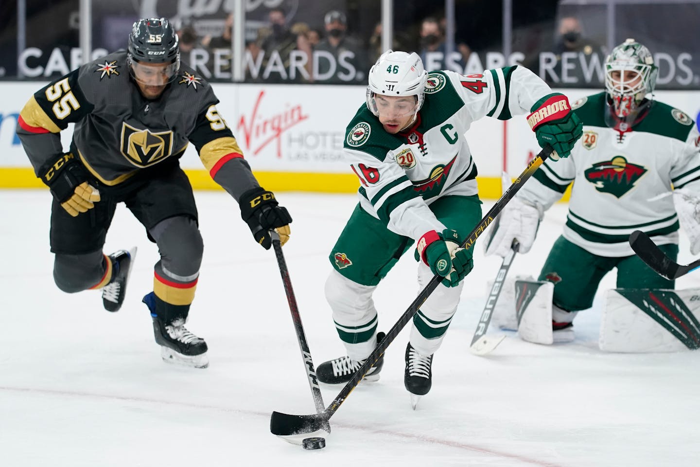 Minnesota Wild left wing Joseph Cramarossa (56) and Vegas Golden Knights right wing Keegan Kolesar (55) vie for the puck during the second period of an NHL hockey game Thursday, April 1, 2021, in Las Vegas. (AP Photo/John Locher)