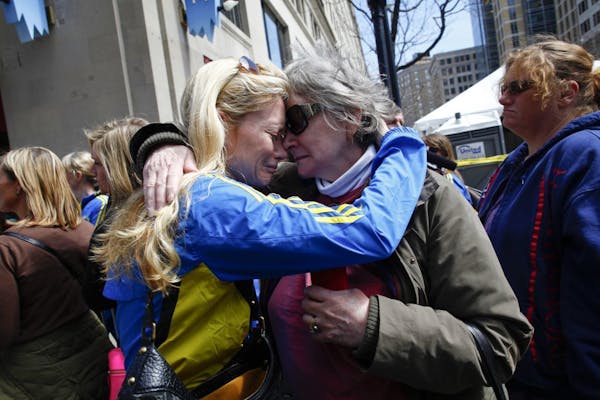 A day after the Boston Marathon, Maureen Johan, right, embraces her daughter Nicole Rand, near the site of two explosions, in Boston, April 16, 2013.