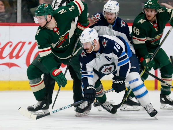 The Minnesota Wild's Charlie Coyle (3) and Winnipeg's Bryan Little (18) jostle during the second period of the Wild's 4-1 win over the Winnipeg Jets S