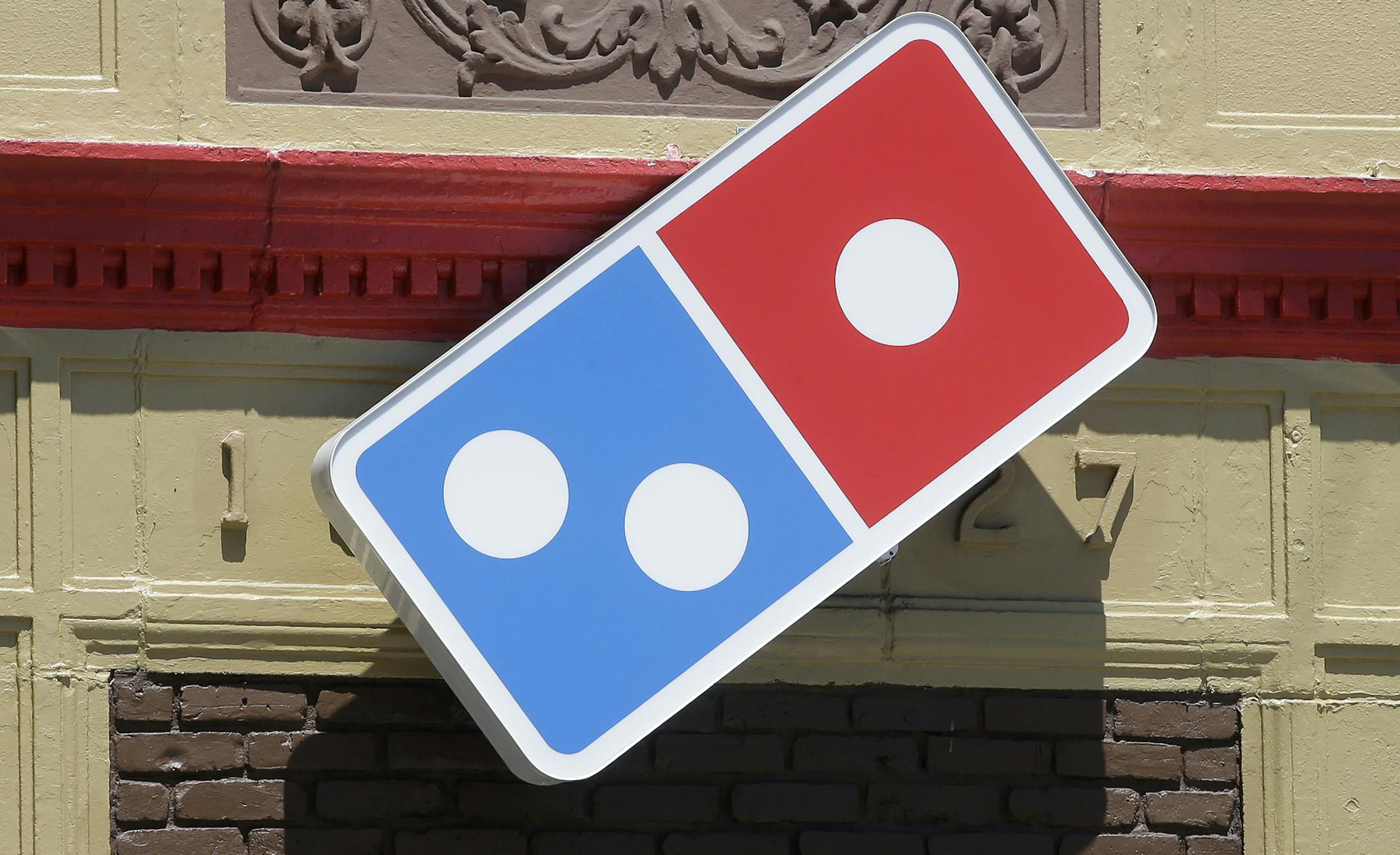In this Monday, July 15, 2019 photo a customer departs a Domino's location holding food items, in Norwood, Mass. Domino's Pizza Inc. reports earns Tuesday, July 16. (AP Photo/Steven Senne)