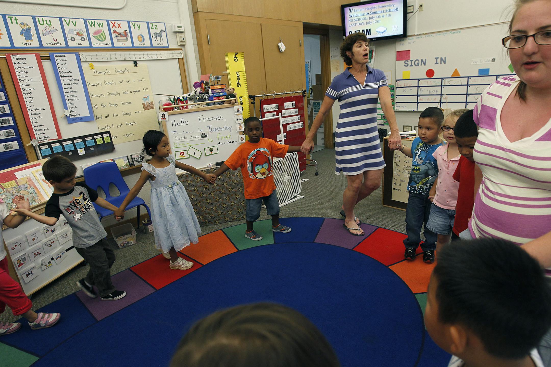 Pre-school teacher Mary Harris, center, led her class in a morning exercise at Eastern Heights Elementary School, Tuesday, July 9, 2013 in St. Paul, MN. (ELIZABETH FLORES/STAR TRIBUNE) ELIZABETH FLORES • eflores@startribune.com