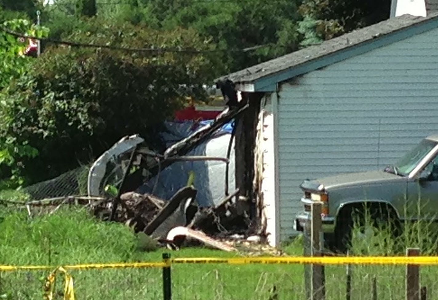 The scene in Maplewood where a helicopter crashed into a garage, narrowly missing a house.