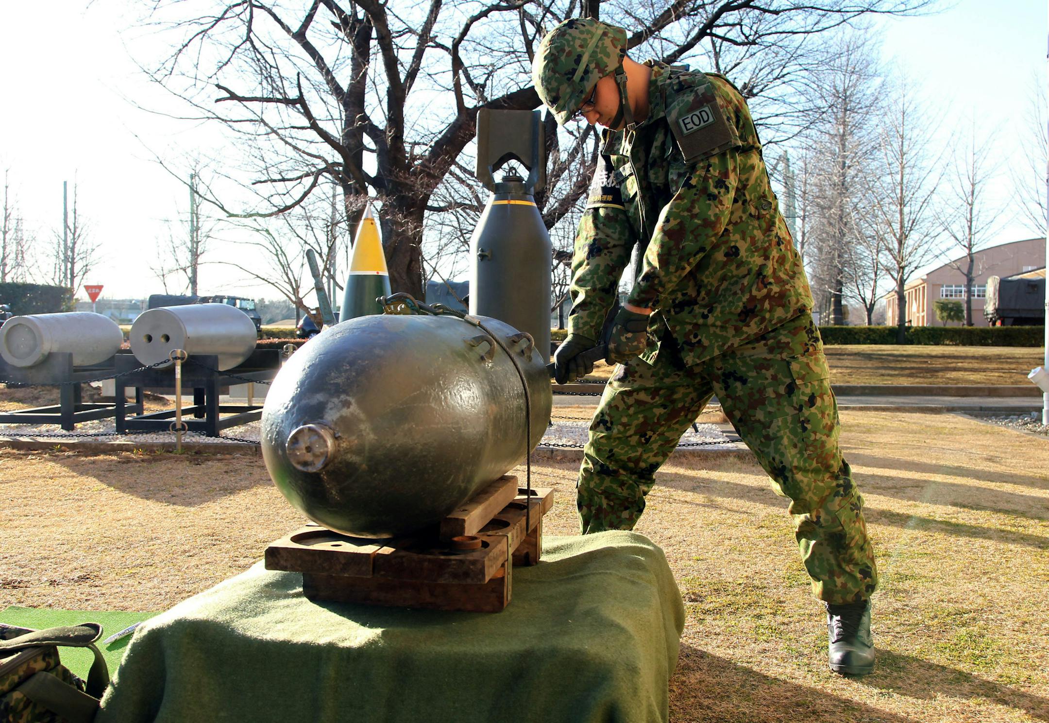 Makoto Ohashi, a member of the Japan Ground Self-Defense Force's bomb-disposal squad, demonstrates the ordnance disposal process at the Ground SDF's Asaka Base in Asaka City, Japan, on Tuesday, Jan. 29, 2013. Almost 70 years after World War II, the Japan Ground Self-Defense Force is still clearing unexploded ordnance scattered throughout the nation, including in central Tokyo, where military bases and headquarters were once located. Photographer: Koichi Kamoshida/Bloomberg *** Local Caption ***