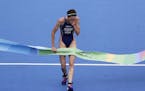Gwen Jorgensen of St. Paul crosses the finish line to win the women's triathlon event at the 2016 Summer Olympics in Rio de Janeiro on Saturday.