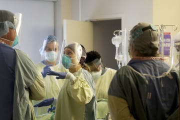 Leah Chapman, center, a registered nurse, conferred with a fellow health care worker after they rotated a COVID-19 patient in the third-floor ICU at B