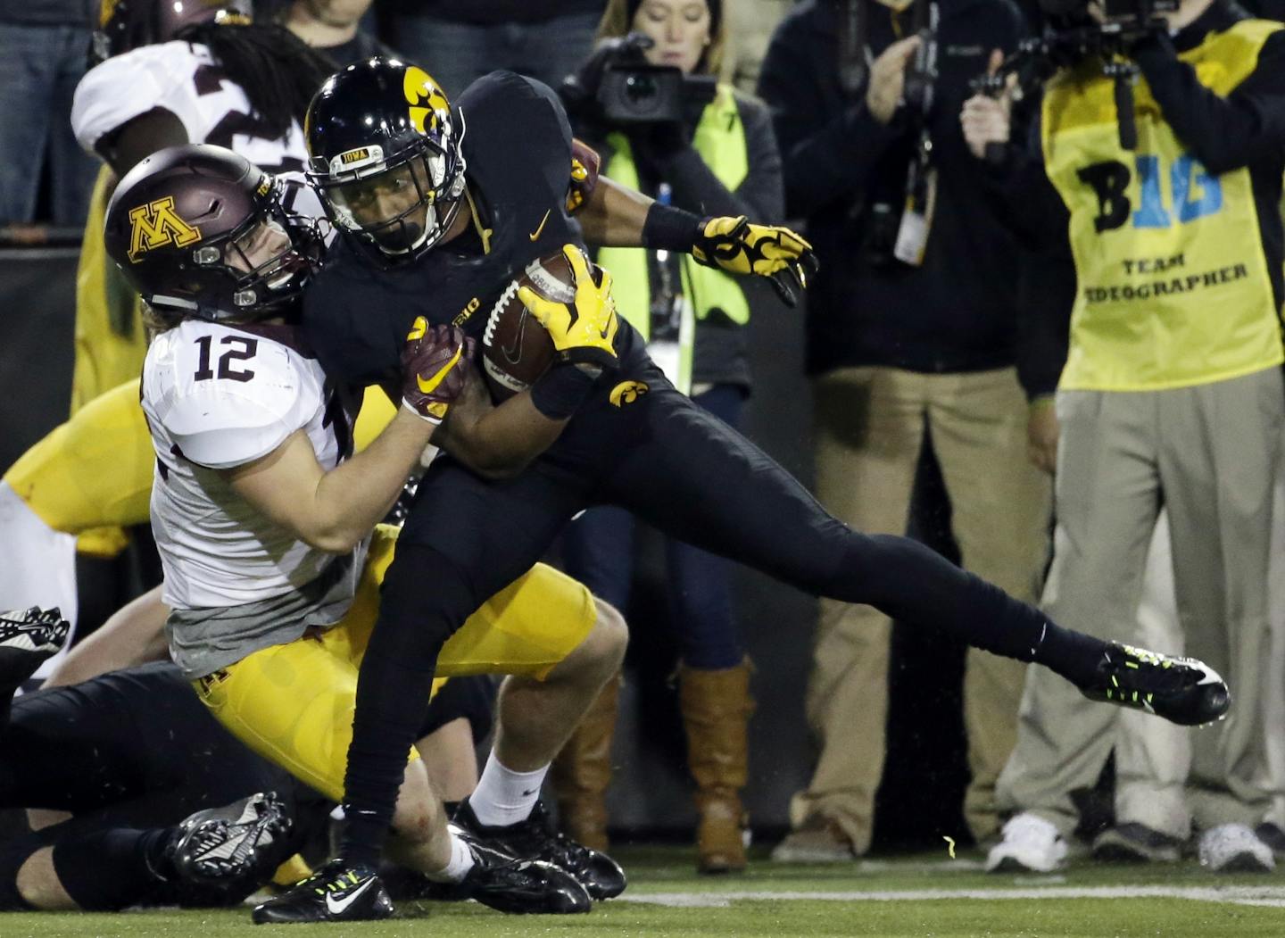 Minnesota linebacker Cody Poock, left, tackles Iowa wide receiver Tevaun Smith during the second half. The catch was part of a 506-yard offensive output against the Gophers.