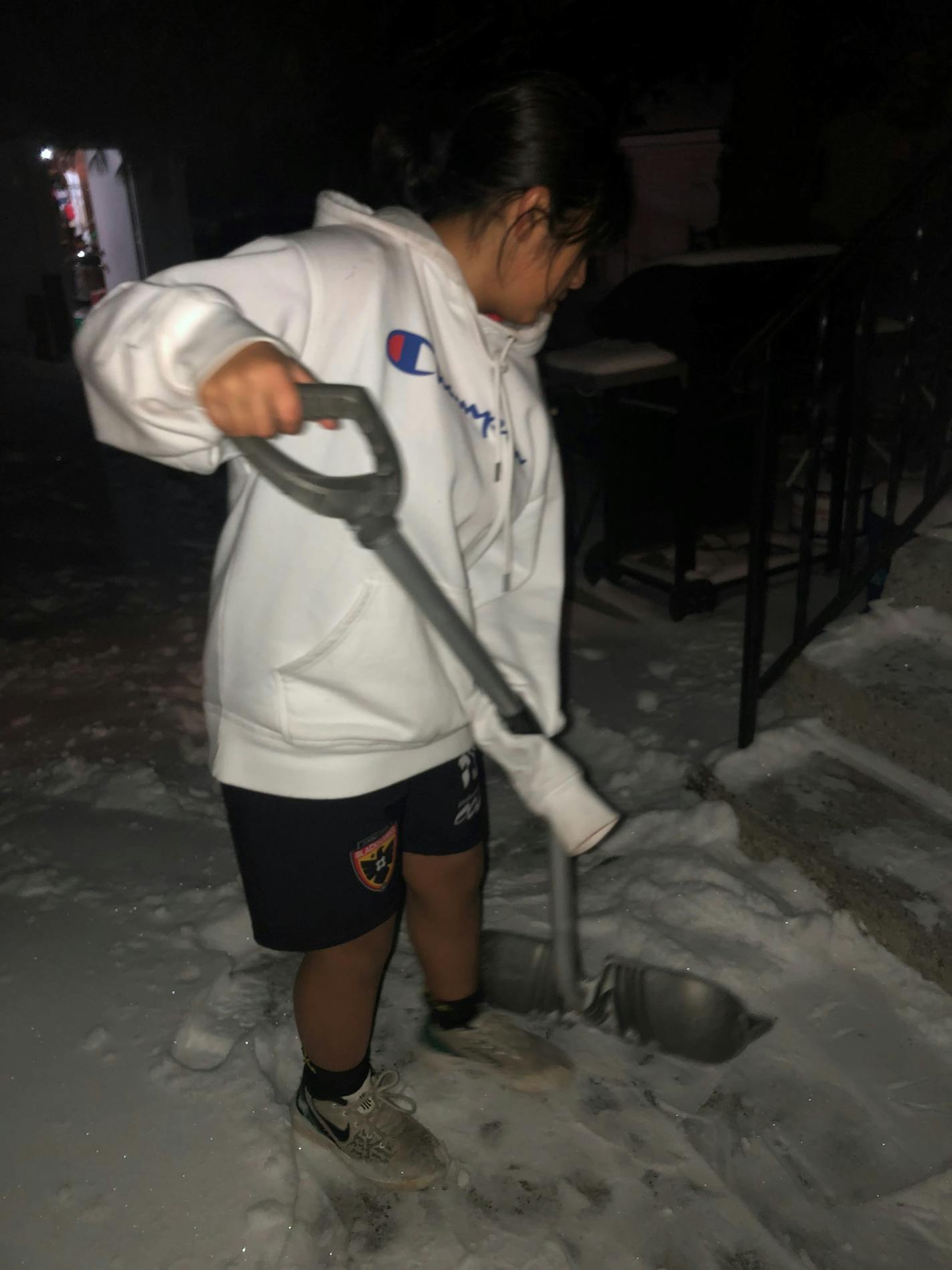 Giselle Sanchez-Esparza, 14, shovels snow outside her St. Paul home in shorts and a hoodie. Provided by Rodrigo Sanchez-Chavarria.