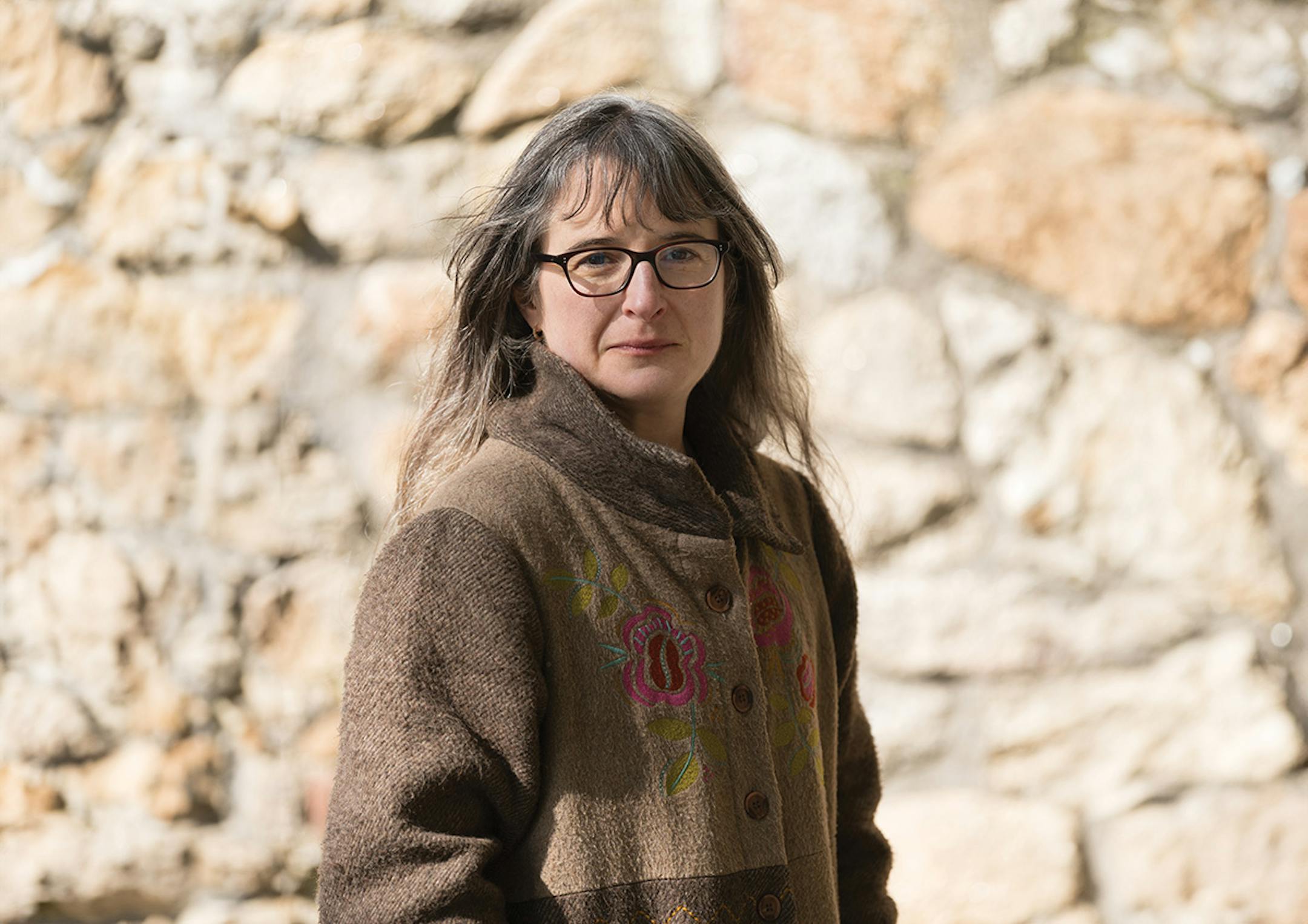 photo of author Sarah Moss in front of a stone wall