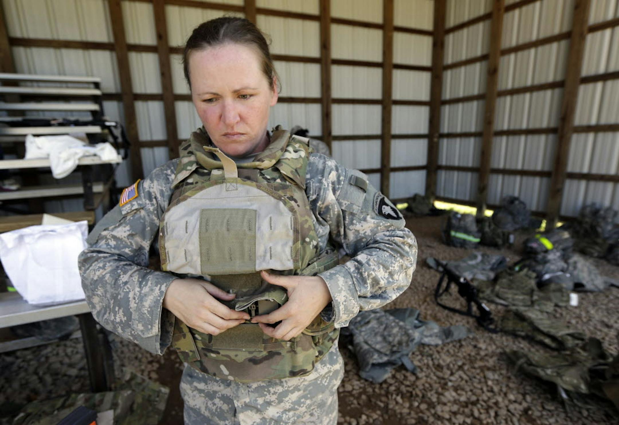 Spc. Sarah Sutphin removes her new body armor after training on a firing range on Tuesday in Fort Campbell, Ky.