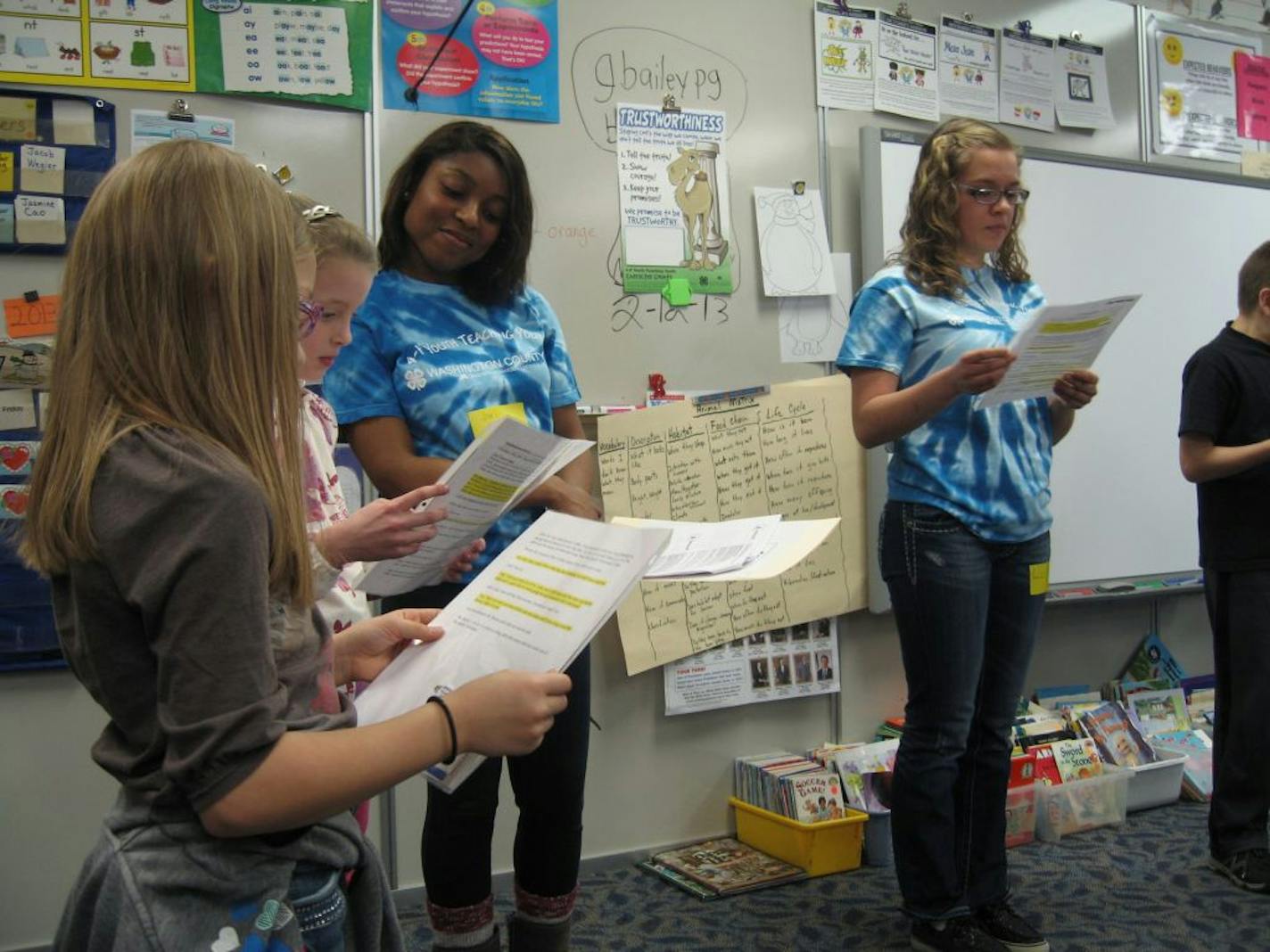 Photo by Andrew Krammer Names (from left to right) Eva Stafne, Ava Ehmke, Jori Cooper (4H), Liz Maatta (4H) Cutline: East Ridge High School students Jori Cooper and Liz Maatta, far right, act out a sketch with Bailey Elementary School second-graders Eva Stafne, far left, and Ava Ehmke as part of a 4H program called "Youth Teaching Youth."