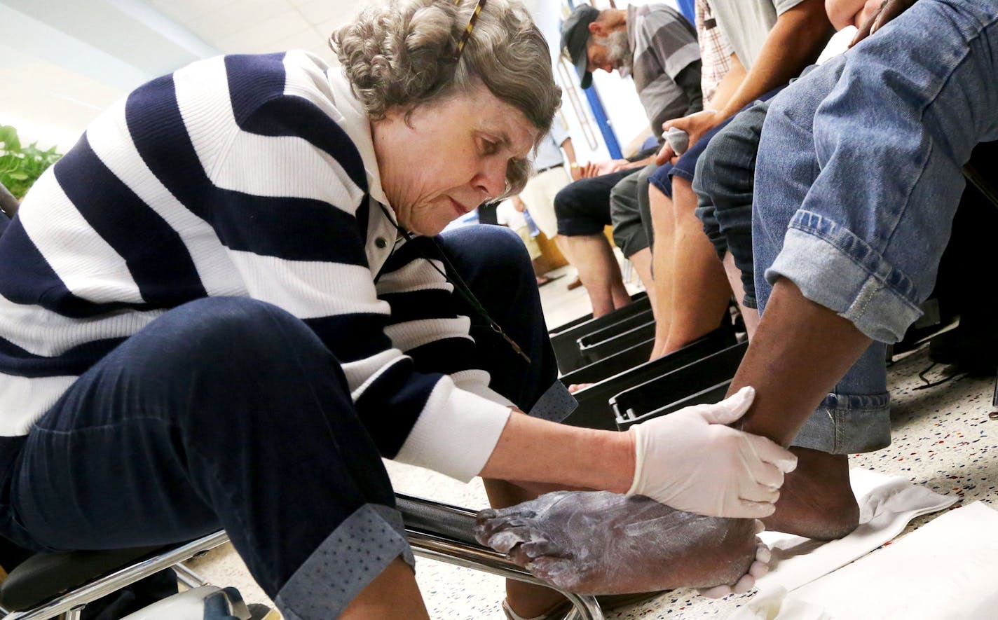 Here, Mary Jo Copeland applies ointment to the sore feet of Albert Watkins at her original facility, Sharing and Caring Hands Thursday, July 16, 2015, in Minneapolis, MN.](DAVID JOLES/STARTRIBUNE)djoles@startribune.com Fifteen years ago, Mary Jo Copeland set off on a high-profile campaign to build a 200-bed orphanage. Since then, she has struggled to raise the $30 million needed for the controversial campus. But for more than a decade she kept the faith, relentlessly promising that someday the f