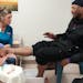Volunteer Chris Niederer talks with Brian Campbell about his feet at SoleCare for Souls at the Catholic Charities Opportunity Center in Minneapolis. 