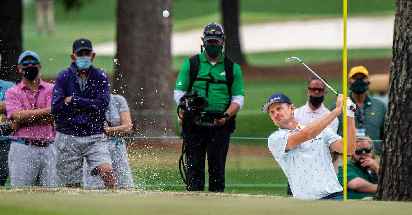 Justin Rose chips out of the bunker on the 15th hole during round one of the Masters