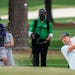Justin Rose chips out of the bunker on the 15th hole during round one of the Masters