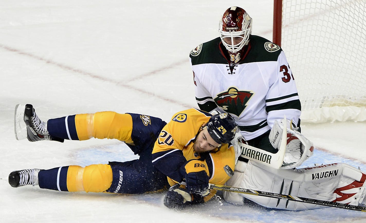 Nashville Predators forward Eric Nystrom, left, collides with Minnesota Wild goalie Niklas Backstrom (32), of Finland, after being slashed, resulting in a penalty shot in the first period of an NHL hockey game on Tuesday, Oct. 8, 2013, in Nashville, Tenn. (AP Photo/Mark Zaleski)