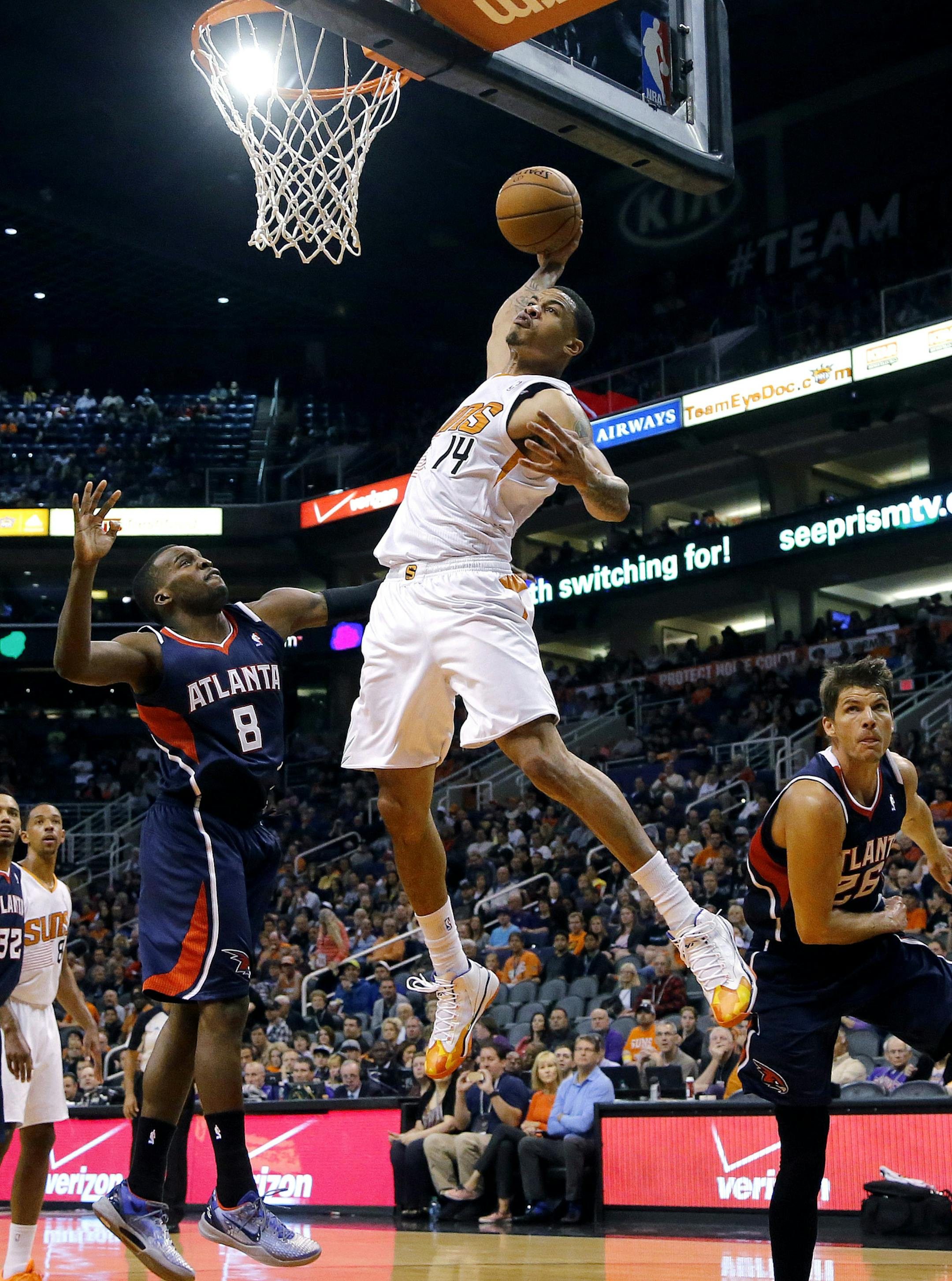 Phoenix Suns' Gerald Green (14) dunks over Atlanta Hawks' Shelvin Mack (8) and Kyle Korver during the second half of an NBA basketball game, Sunday, March 2, 2014, in Phoenix. The Suns won 129-120. (AP Photo/Matt York)