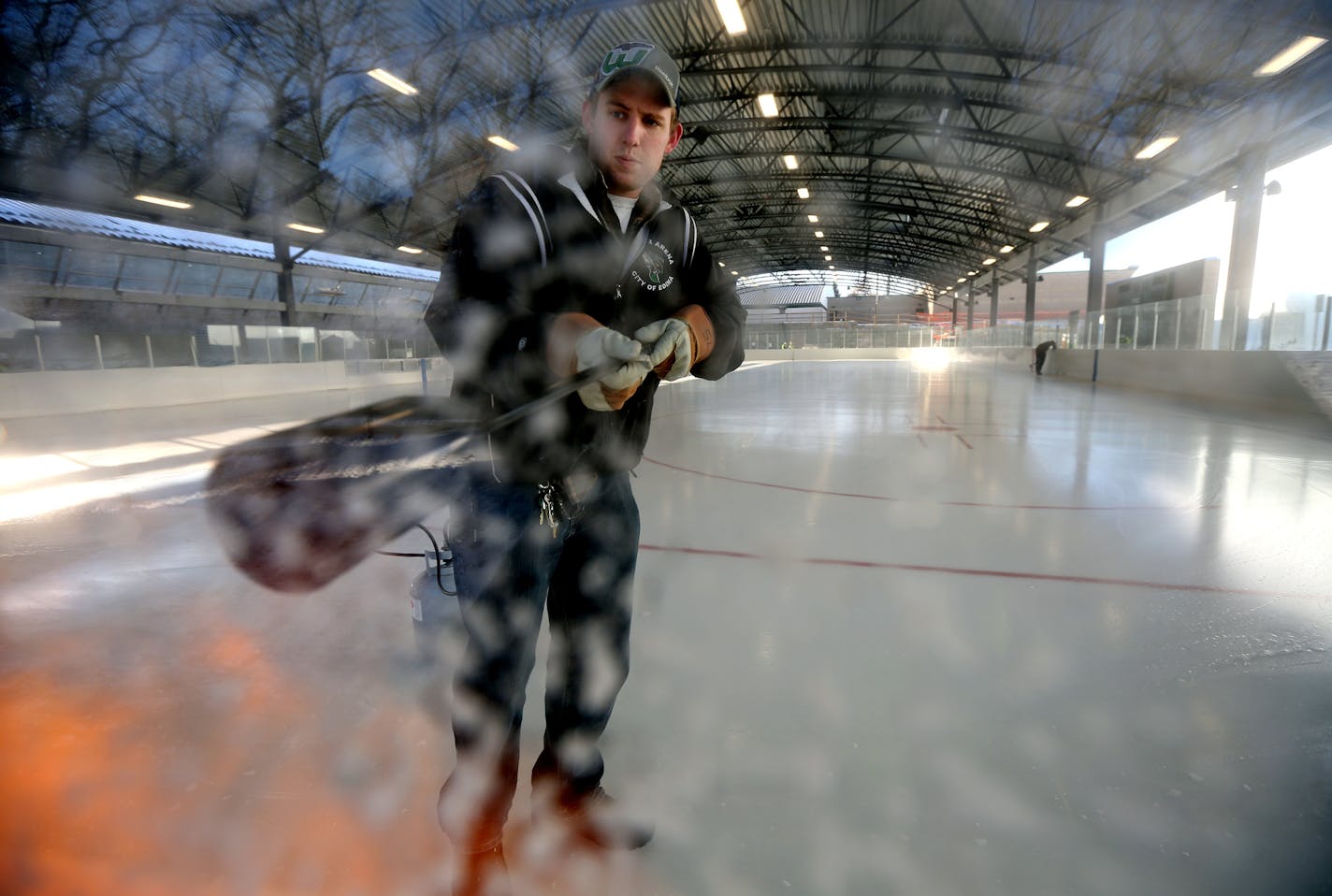 Sean Larson melted ice around the top of the boards on the new outdoor rink at Braemar Arena. The rink is next to the new inflatable sports dome structure in Edina Wednesday December 3, 2014 in Edina, MN. ] Jerry Holt Jerry.holt@startribune.com