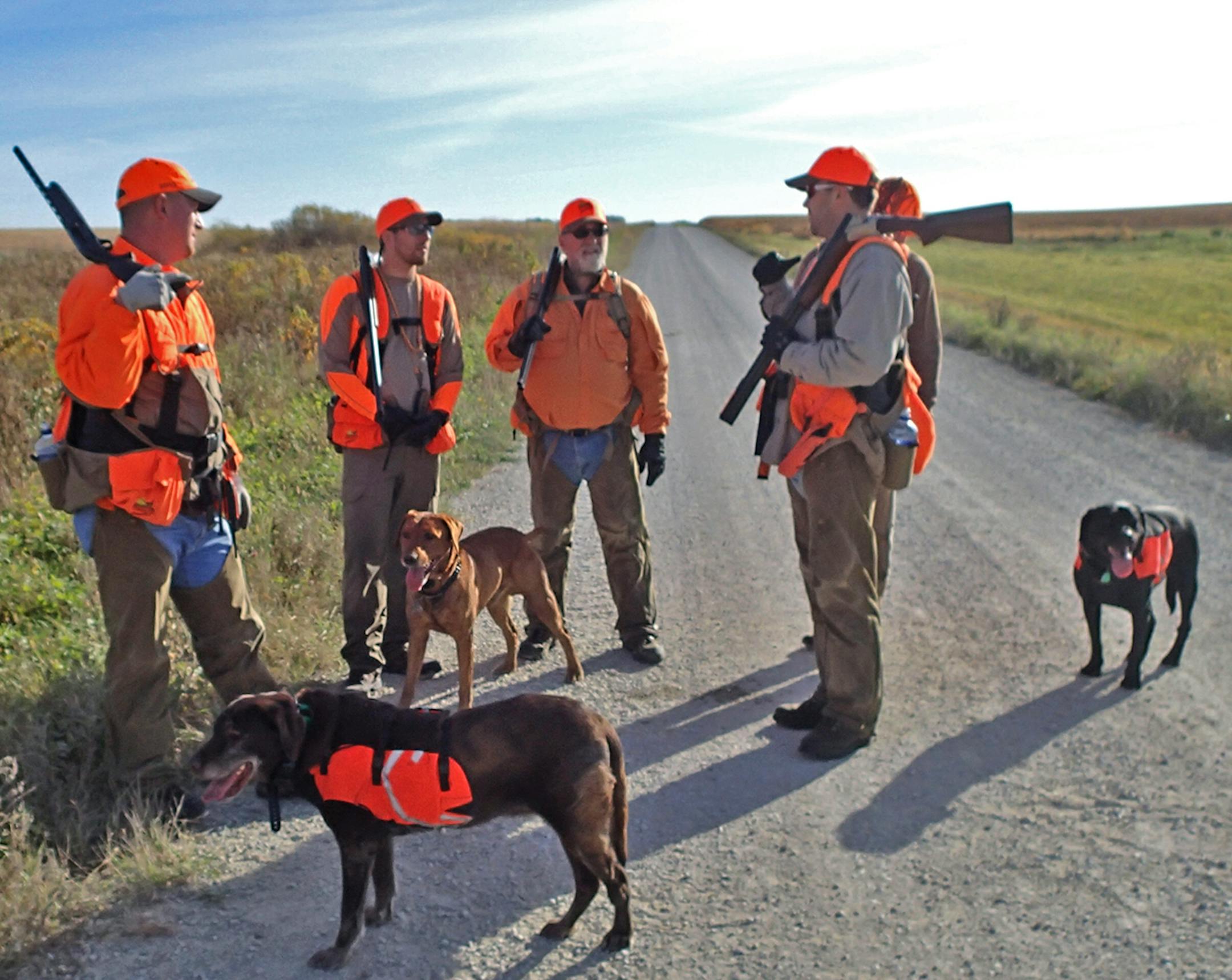 Making a plan: James Wendel, left, Logan Hinners, Logan’s dad, Neal Hinners, Kale Hinners (hidden) and Andy Ness rendezvoused on a gravel road during Saturday’s hunt.